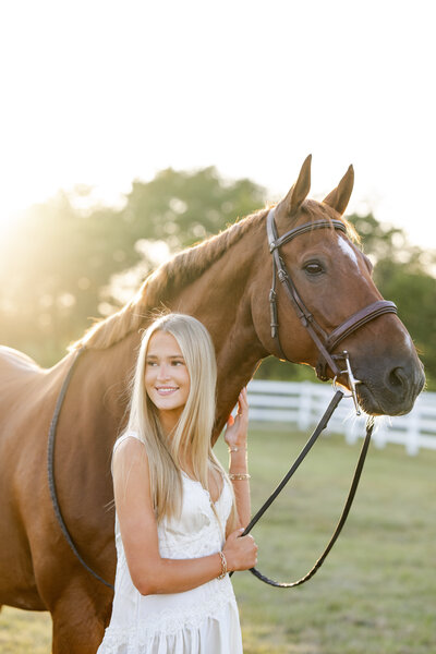 Westfield high school senior smiles with her horse during golden hour portrait session