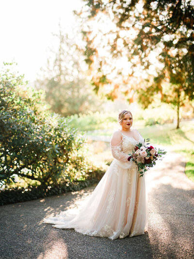 Bride holding a bouquet under sunlight