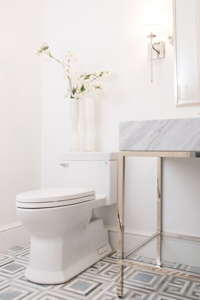 Luxury powder room on Comm Ave featuring a blue marble floor, elegant vanity, and brass fixtures