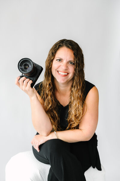 Photographer Janelle Reule editing an image on her computer with her camera and coffee next to her.
