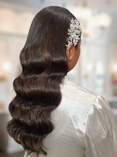 Soft Hollywood glam waves cascading down a bride’s shoulders, styled with a deep side part for a classic, elegant look.