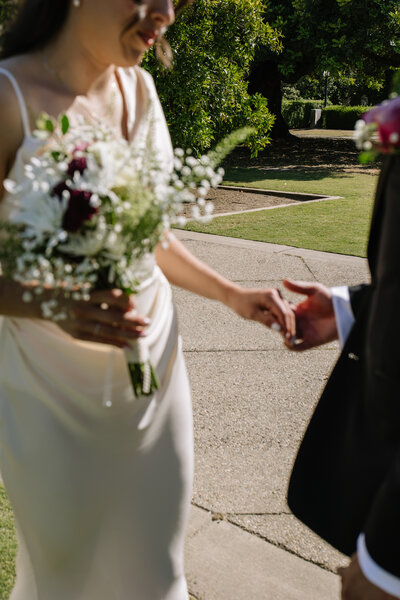 Katie and Sebastian holding hands out of focus.