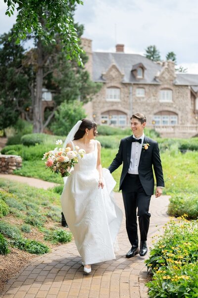 Couple walks together at Highlands Ranch mansion 