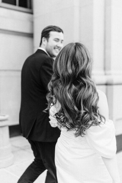 black and white engagement photo of couple walking away from the camera