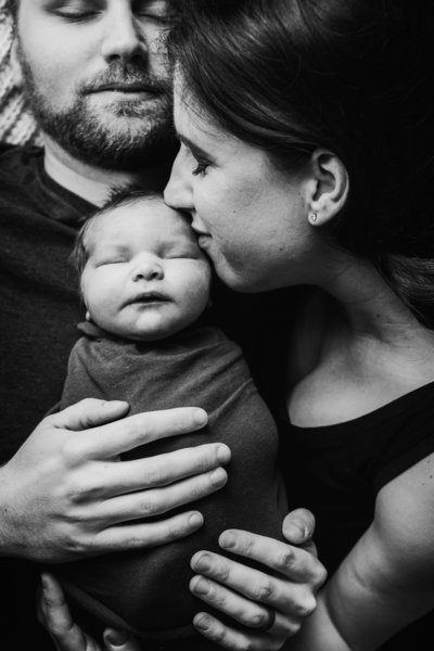 Black and white portrait of family and newborn