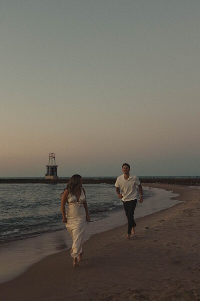 Romantic engagement session featuring a couple walking hand-in-hand along a serene beach at sunset, capturing love, joy, and the beauty of togetherness