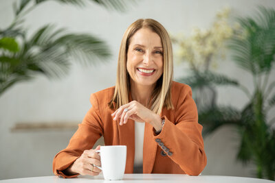 Nancy Himmelfarb posing for a portrait while holding a mug