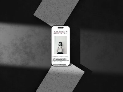 Laptop on a white desk displaying an eCommerce website with rum-themed products, including a rum bottle, rum lovers journal, and a Caribbean cookbook, lit by natural sunlight with a glass of water and dried florals beside it.