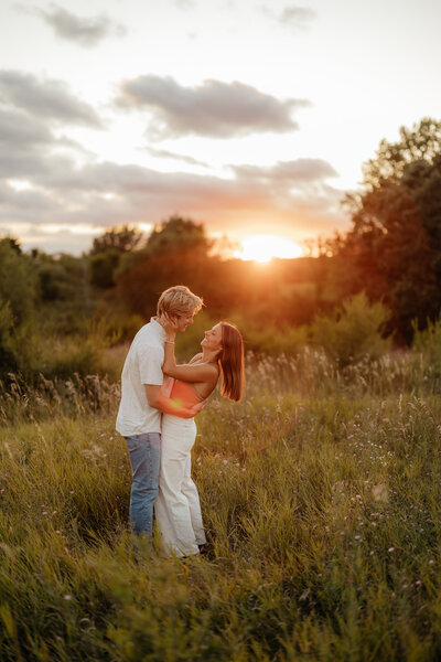 man and woman kissing in front of rock formation