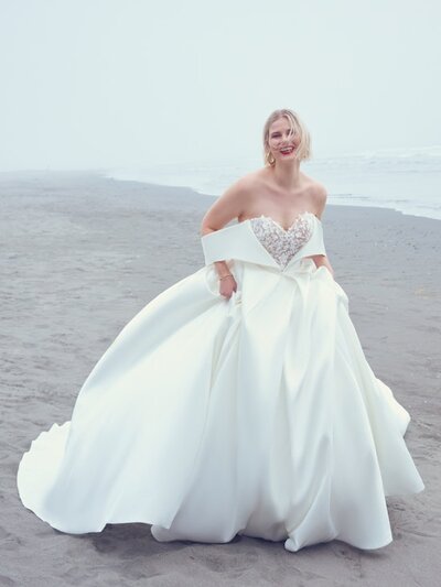 Ball Gown Wedding Dress. A breathtaking choice for the unconventional bride, this wedding dress features contrasting layers of tulle, lace motifs, and Chantilly lace. The sheer bodice features illusion long sleeves, a plunging V-neckline, and scoop back, all accented in 3D floral lace motifs. Hemline trimmed in horsehair, completing the tulle ballgown skirt. Includes detachable modesty panel option for a demurer neckline. Finished with covered buttons over zipper closure.