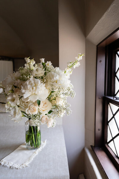 couple holding flower bouquets embracing