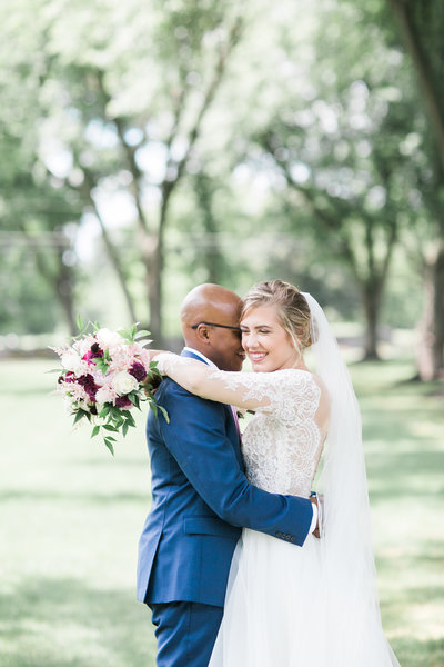 bride and groom sitting on a stone wall