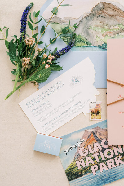 Customized calligraphy flat lay featuring wedding invitations, envelopes, flowers and more represent full service design by Life in Letters.