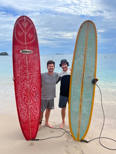 Men on beach with surfboards - Santai Retreats 