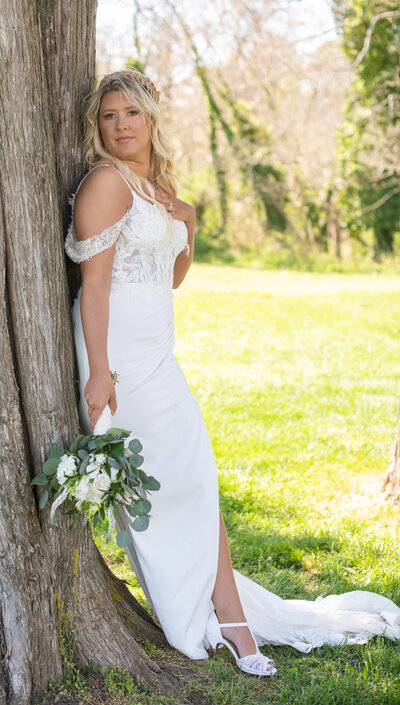 Bride leaining against a tree with bouquet before Traditional Wedding - Jennifer Mummert Photography - Southern Maryland