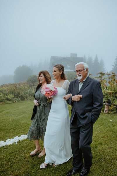 parents walking their daughter down the aisle