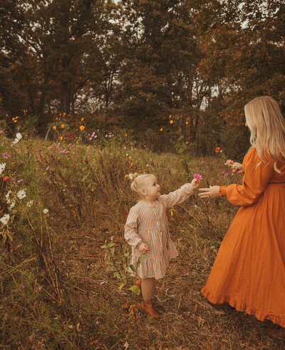 daughter picking flowers for her mom in a flower field