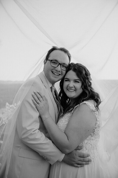 photo of bride and groom smiling under the veil