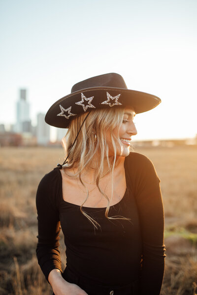 Girl wears cowgirl hat during senior photoshoot