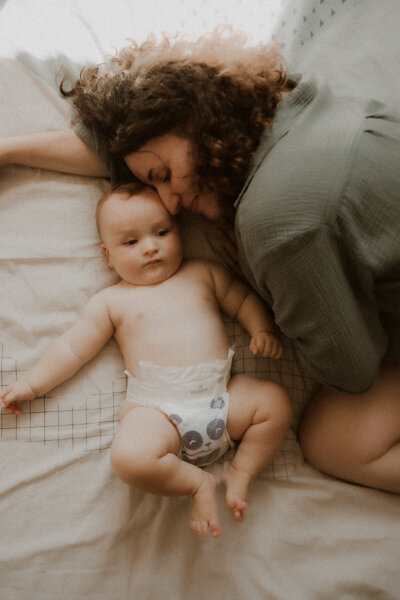 photo sur le lit bebe allonge contre sa maman interieur cannes-alpes-maritimes