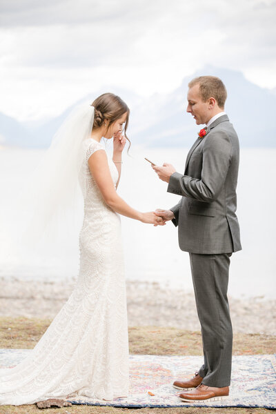 Bride holding a beautiful bouquet of flowers kissing her groom