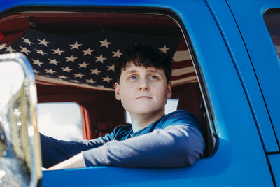 senior-boy-sitting-in-truck-with-flag
