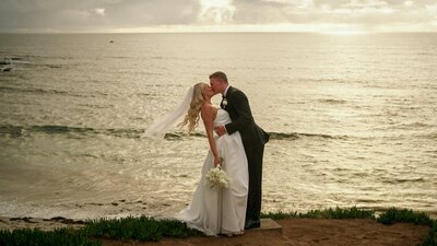 bride and groom kissing at wedding on san diego beach