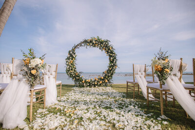 Outdoor beach wedding ceremony site with florals