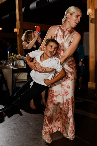child being swung around on the dance floor at a wedding