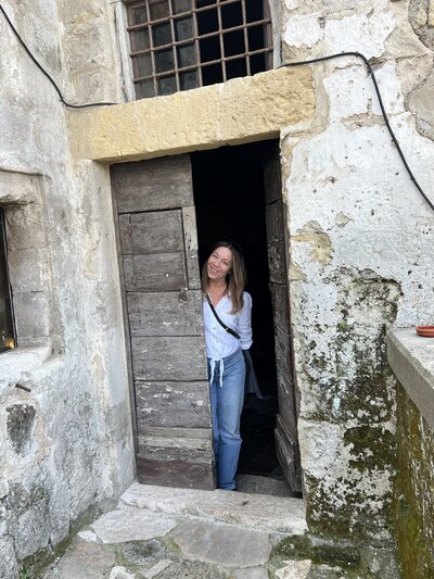Guest standing in the doorway of a rustic cave room at the Sextantio hotel, Matera