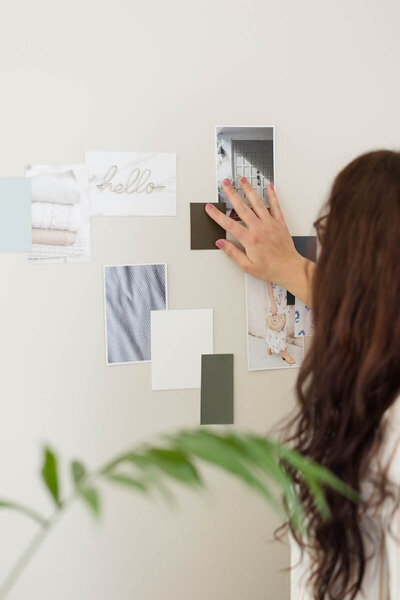 Brand and website designer Aubre Walther of Artisan Kind creating a mood board on a wall