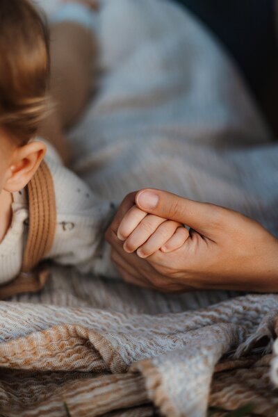 Close Up von einer kleinen Kinderhand und der Hand der Mutter