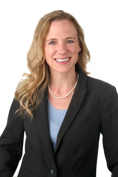 smiling woman with long blonde hair wearing a black blazer