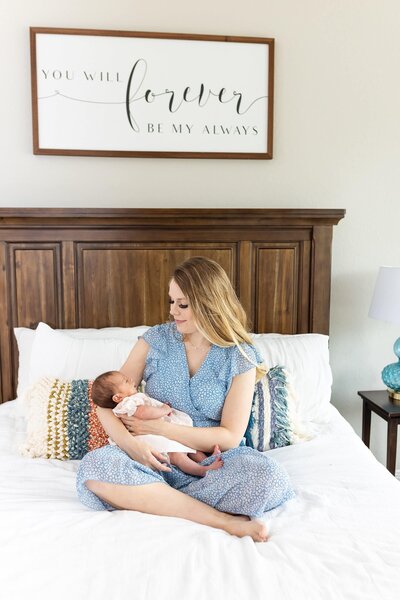 Mom holding newborn on bed