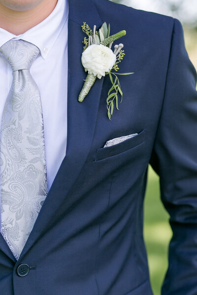A close-up of the groom's suit at chest level.