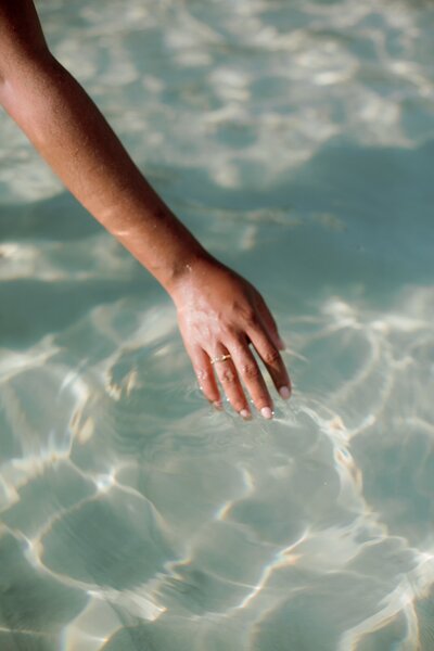 Woman gently dragging her hand over the water