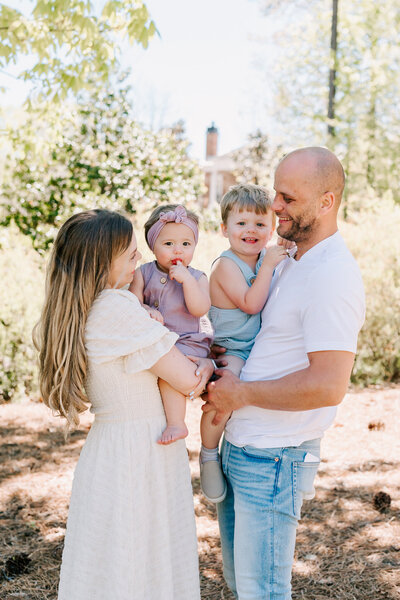 Parents smiling at each other while two children are smiling at the camera