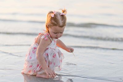 Toddler playing with sand in the ocean shoreline