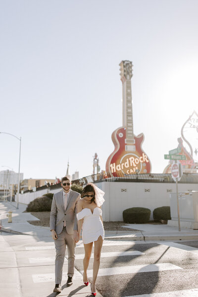 A couple walks hand in hand at The Neon Museum during their elopement.