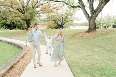 Family walking down a path under oak trees