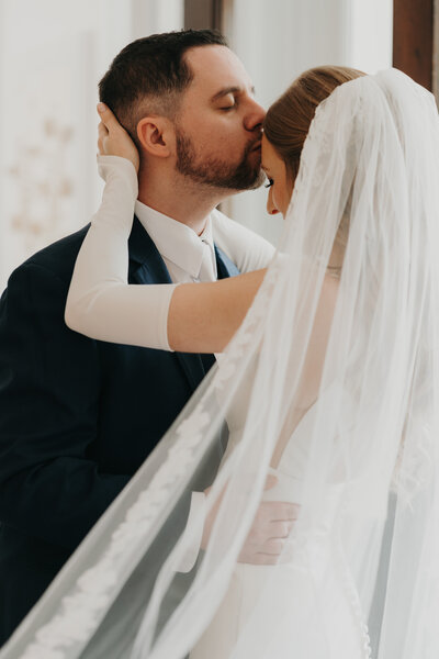 Groom kissing brides forehead