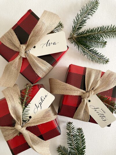 Custom gift tags with black ink calligraphy on holiday gifts