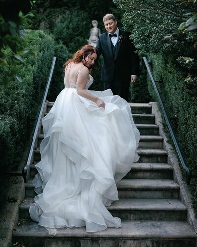 Groom helping bride up stairs at Trump Winery.