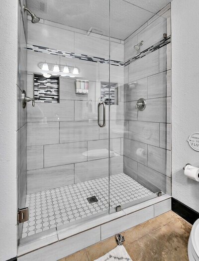 Luxury walk-in shower with dual heads in the bathroom of this studio vacation rental condo in the historic Behrens building with a 5th floor view of downtown Waco, TX