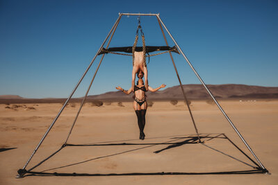 Couples Photo of Acrobatics, wearing lingerie, hanging from chains, in a desert landscape scene
