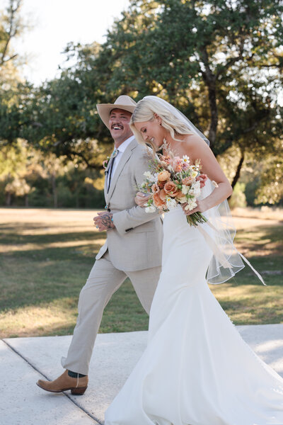 bride and groom get picture taken while walking to their ceremony