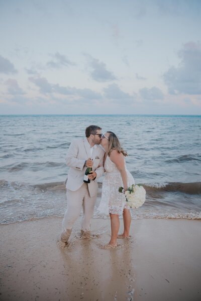 Destination Elopement Photographer captures couple kissing on the beach after intimate wedding
