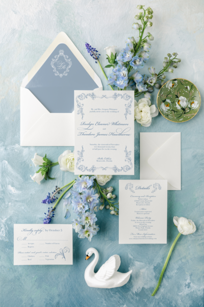 elegant wedding invitation with vintage ornate borders in a soft blue