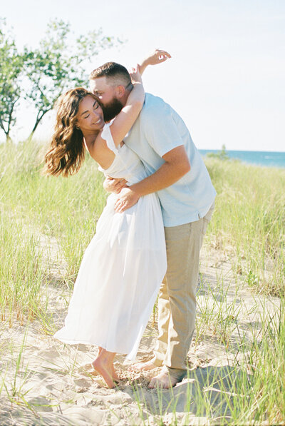 married couple holding a parasol snuggling 