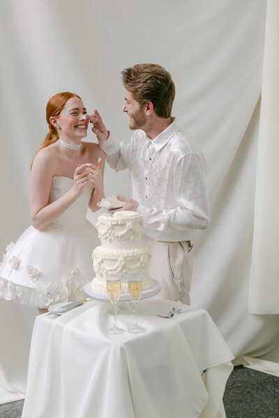 dallas couple having fun with wedding cake